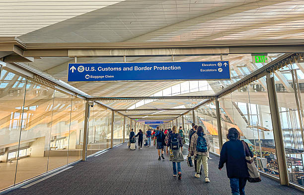 Travelers walking toward U.S. Customs and Border Protection at an airport