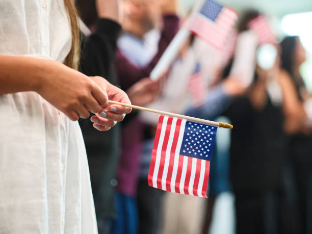 A hand holding a small U.S. flag