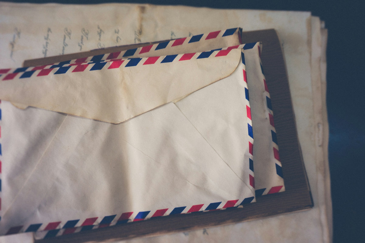 Stack of vintage airmail envelopes with red and blue striped borders