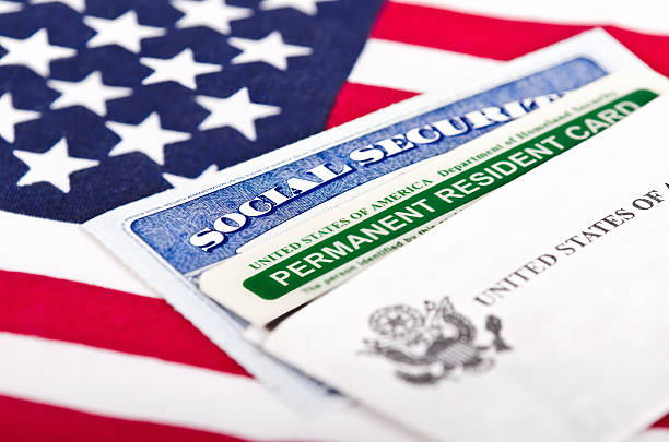 A Social Security card and a permanent resident card on a U.S. flag